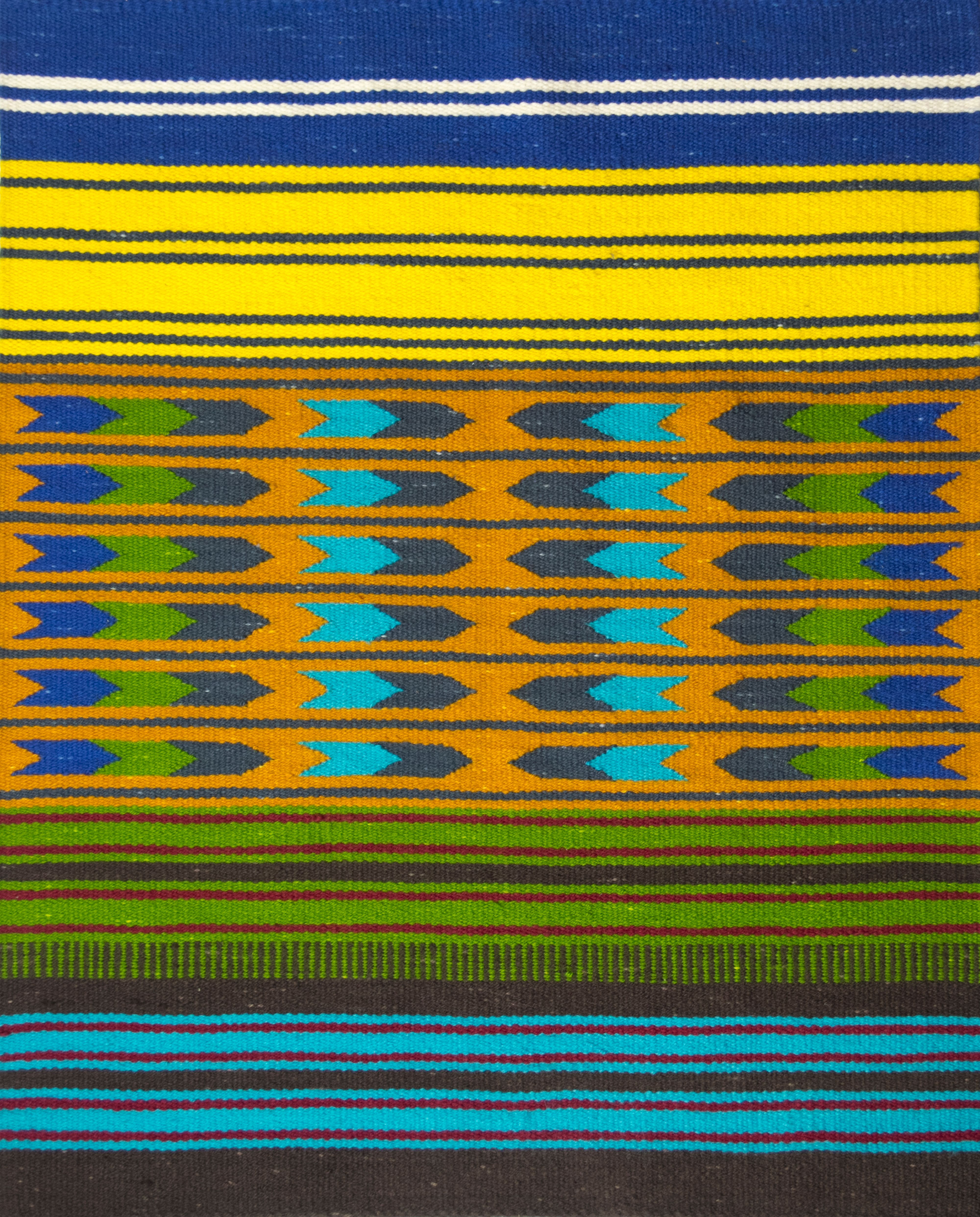 This photograph features a wool rug, dominated by horizontal stripes of blue, yellow, orange, green, and brown. The orange stripes in the center of the rug are embellished with arrow-like, geometric shapes in blue and green.